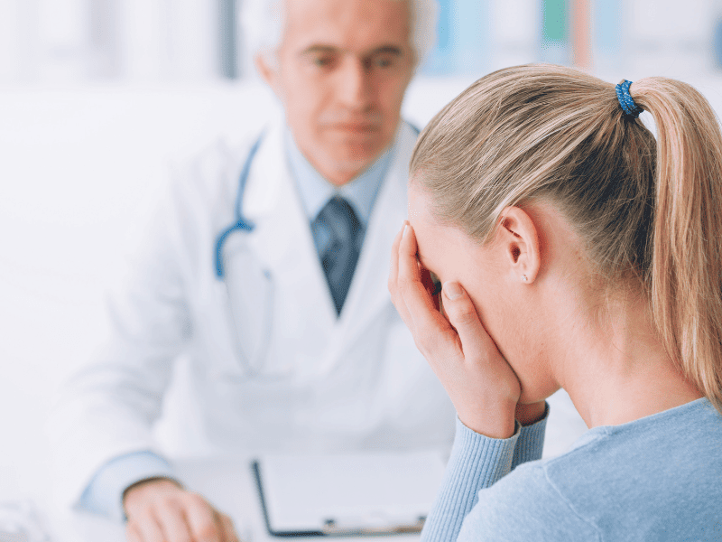 Patiente femme qui est triste car son médecin homme ne prends pas en considération sa douleur exprimée.