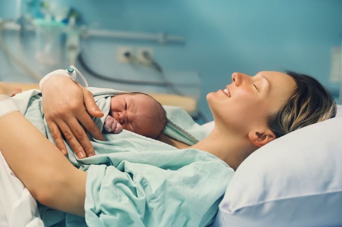 Femme tenant son bébé dans ses bras suite à l'accouchement.