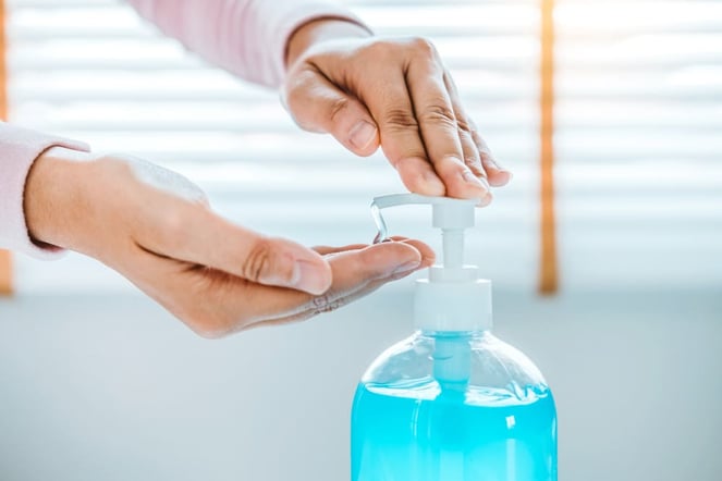 Homme prenant un solution nettoyante pour les mains contenant de la chlorhexidine, ayant un potentiel risque d'allergie.