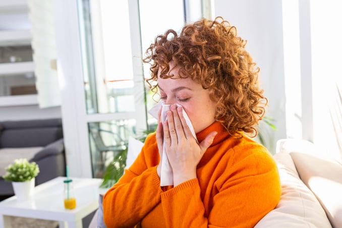Femme se mouchant le nez ayant une réaction allergique à la chlorhexidine.