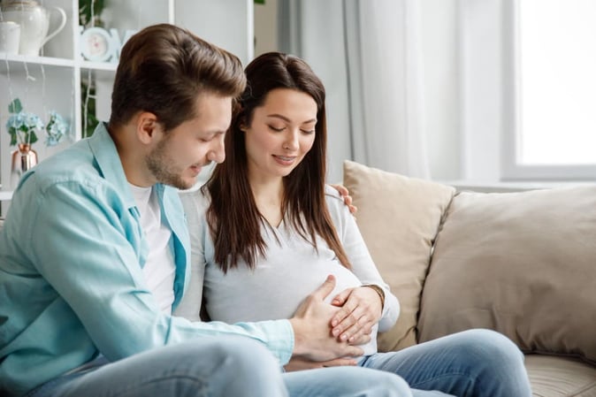 Des futurs parents touchent le ventre de la femme pour créer un lien avec le futur bébé.