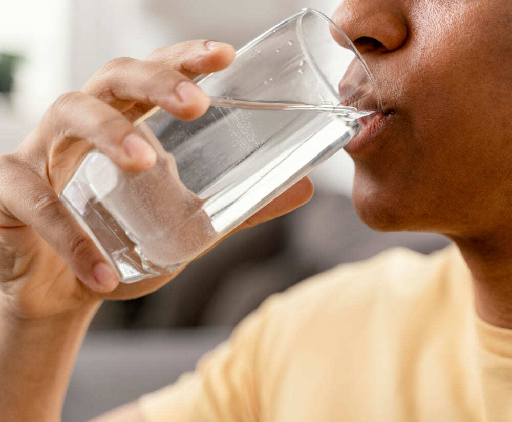 Eau potable avec des polluants émergents bu par un homme