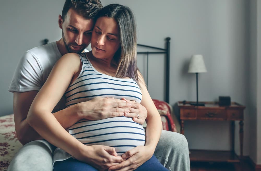 Femme enceinte et son mari faisant une séance d'haptonomie.