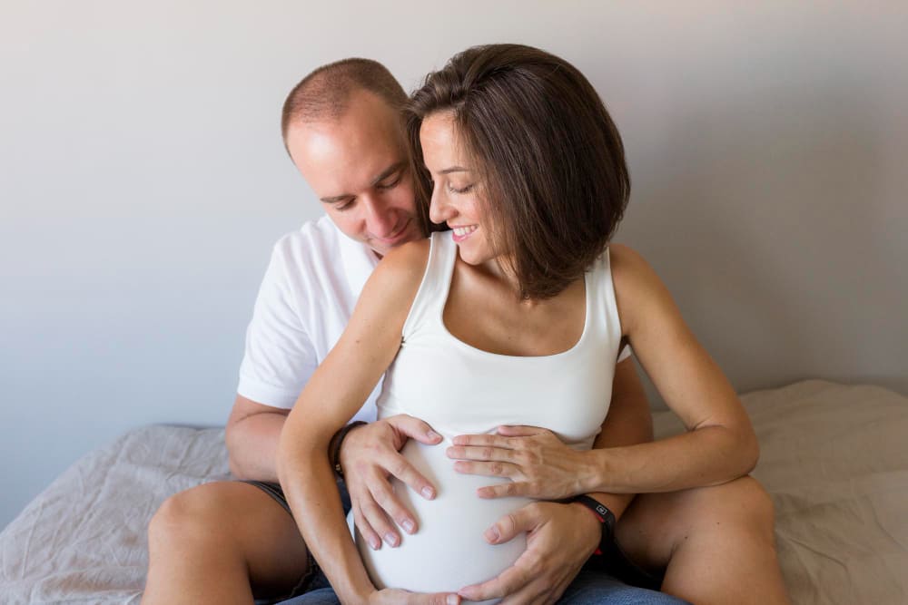 Femme enceinte et son mari réalisant leur cinquième séance d'haptonomie.