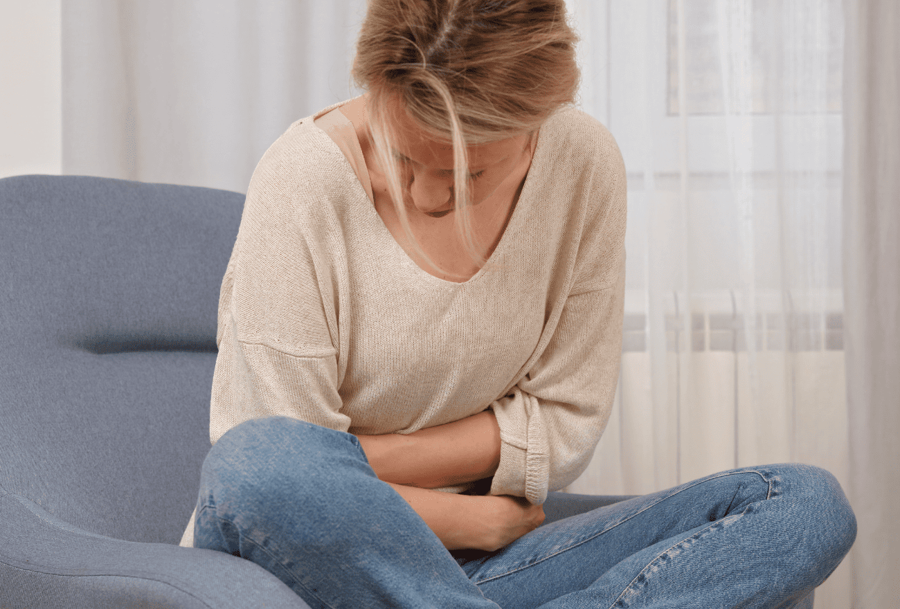 Femme qui subit une infection urinaire avec tous ses symptômes