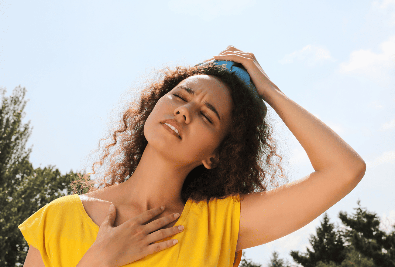 Femme qui sait ce qu'il faut faire lors d'une insolation en mettant un linge humide sur sa tête