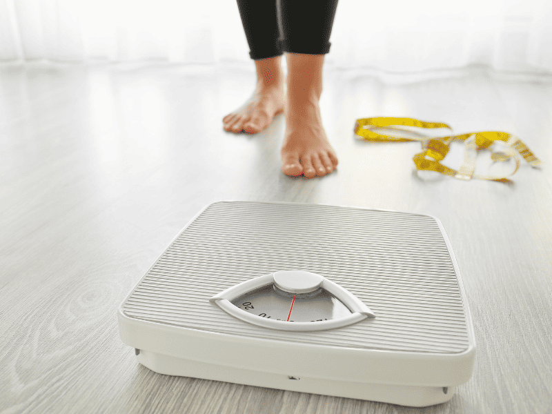 Femme allant sur une balance pour se peser pour faire face à son obésité.