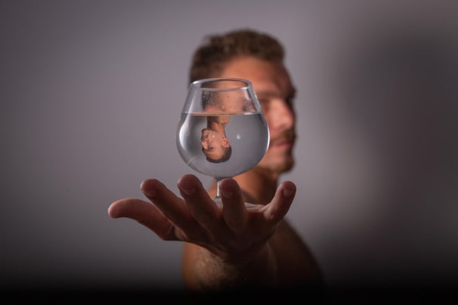 Symbole du karma d'un homme se reflétant dans un verre d'eau
