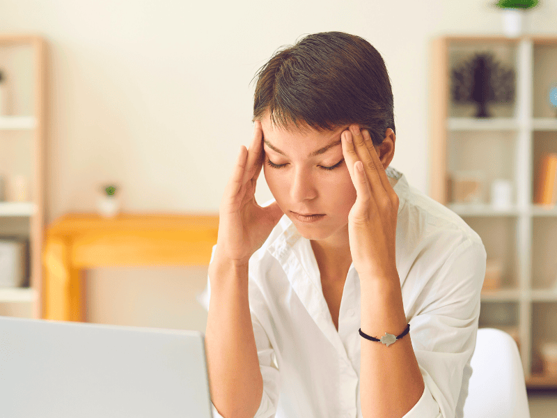 Femme travaillant sur son ordi avec une migraine