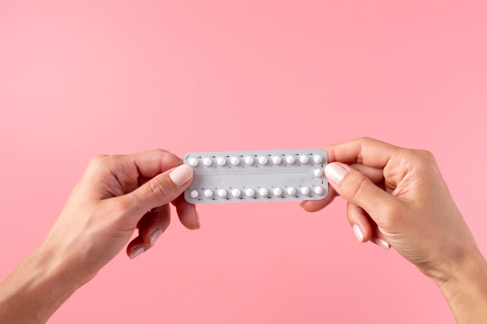 Femme qui tient une plaquette de pilule entière dans ses mains.