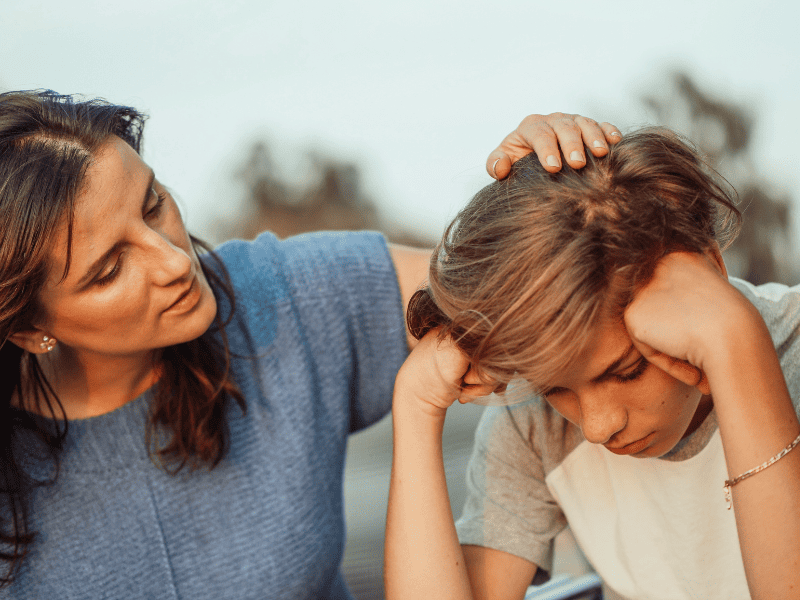 Mère réconfortant son fils adolescent car il est en dépression.