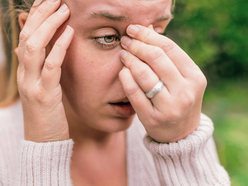 Femme ayant mal au niveau de l'arête du nez à cause d'une sinusite.