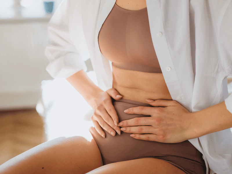 Une femme qui se tient l'abdomen ayant un type d'endométriose.