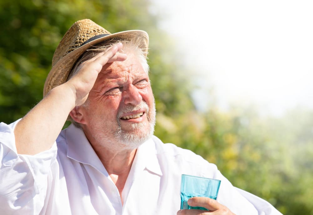 Personne âgée qui a très chaud au soleil à cause d'une vague de chaleur.