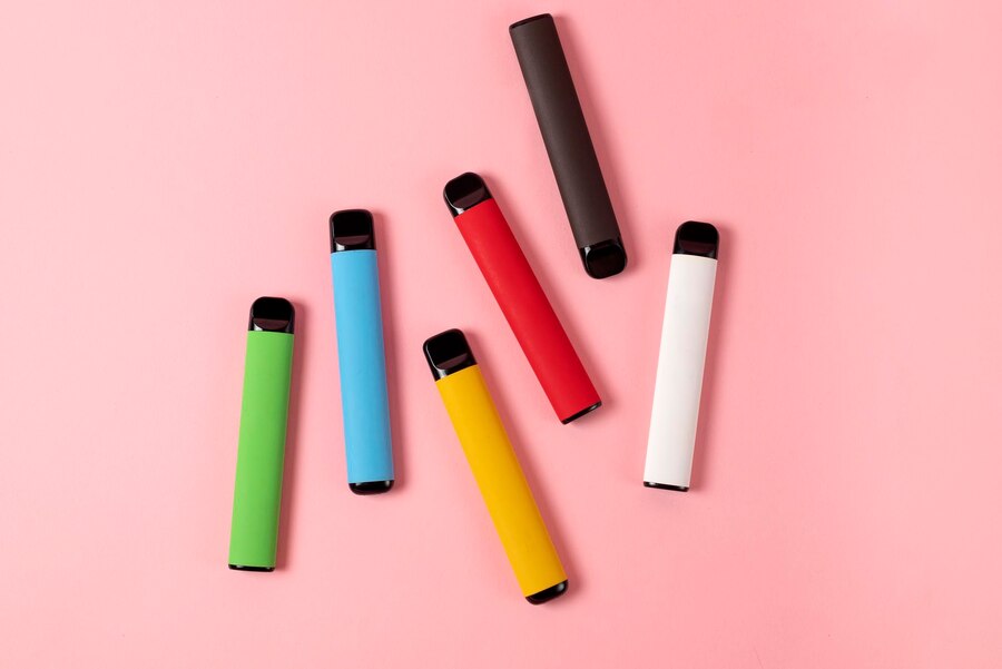 assortiment de puffs cigarettes électroniques jetables sur fond coloré 