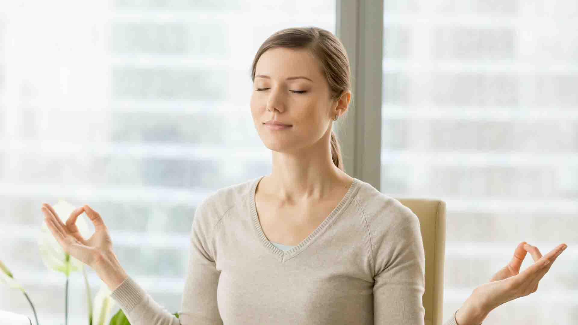 femme détendue au travail adoptant une technique de gestion du stress, relaxation méditation