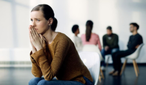 Femme souffrant d'anxiété sociale à côté d'un groupe de personnes.