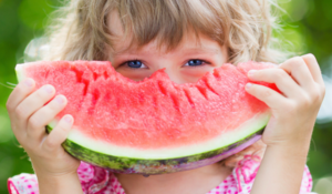 Une enfant qui mange en cette forte chaleur une pastèque
