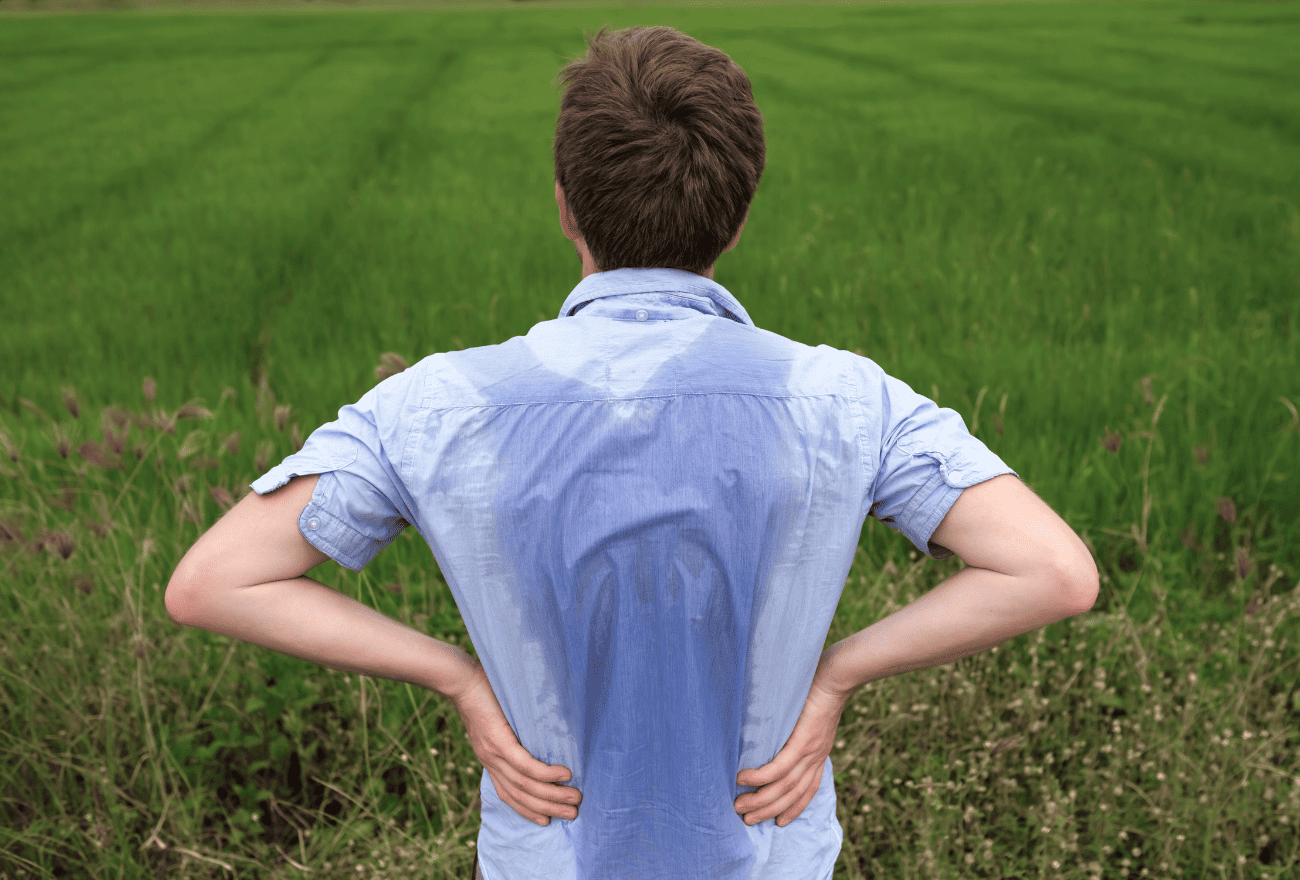 Homme ayant une transpiration excessive dans le dos, appelée Hyperhidrose.