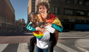 Couple d'hommes homosexuels souriant dans la rue.