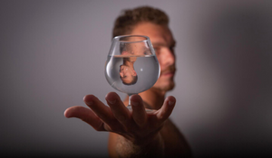 Symbole du karma d'un homme se reflétant dans un verre d'eau