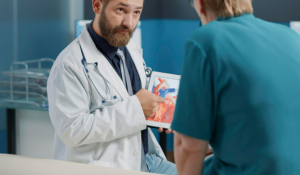 Cardiologue qui montre à un patient une illustration d'un cœur.